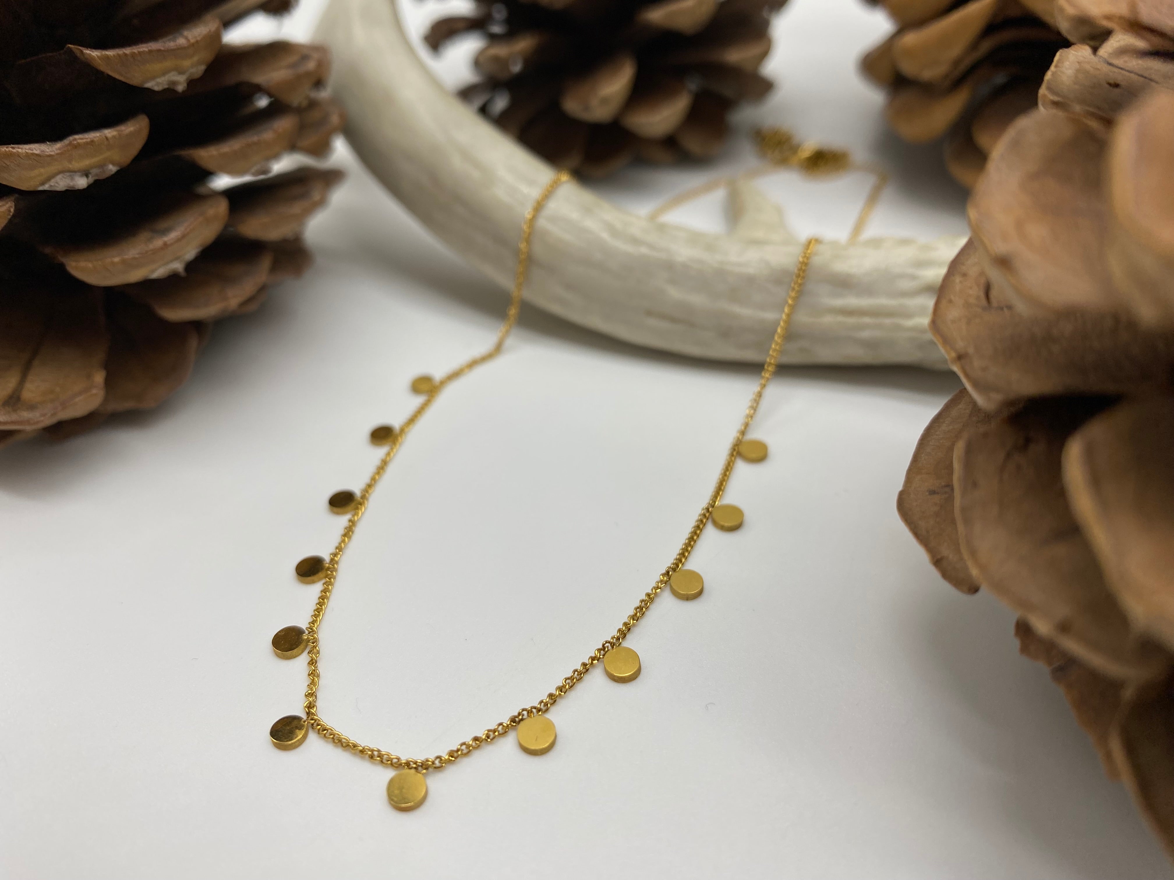 Waterproof minimalistic layering necklace with little circles available in gold and silver.